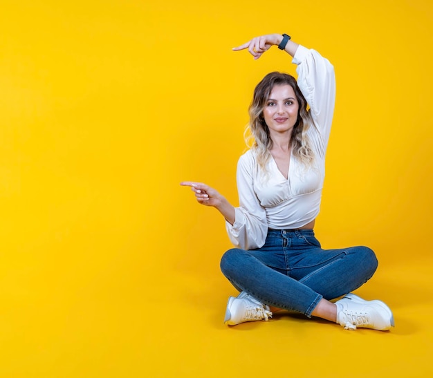 Woman use index fingers pointing to copy space Full body cheerful excited girl sit floor