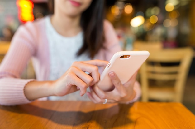 カフェで携帯電話を使う女性