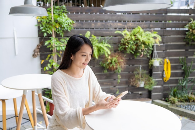 カフェで女性が携帯電話を使う