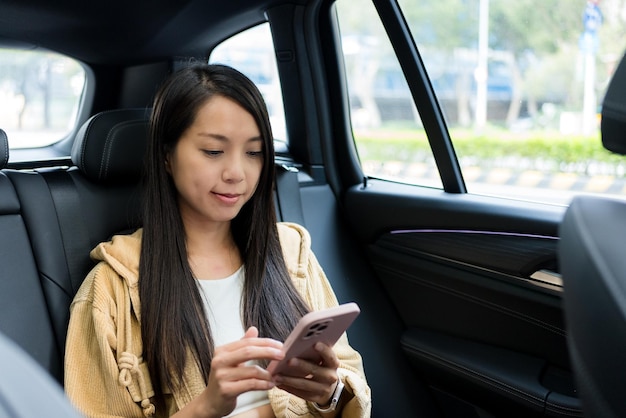 女性が車の中で携帯電話を使う