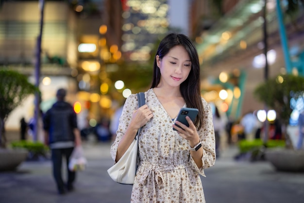 Woman use of mobile phone in city at night