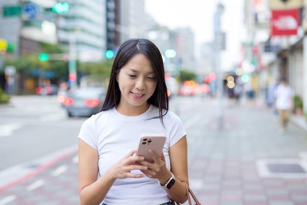 女性が街で携帯電話を使う