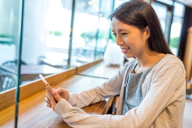 喫茶店で携帯電話を使う女性