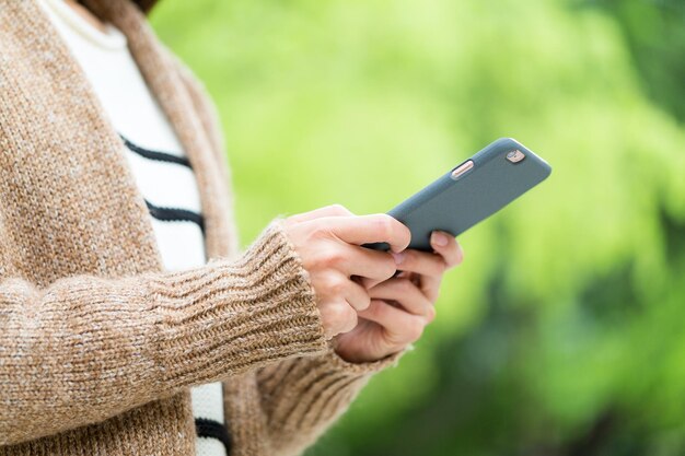 緑の背景の上に携帯電話を使用する女性