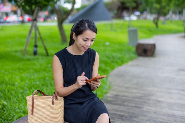 女性が屋外で携帯電話を使う