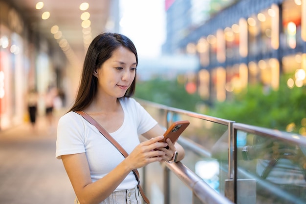 女性が屋外で携帯電話を使っている