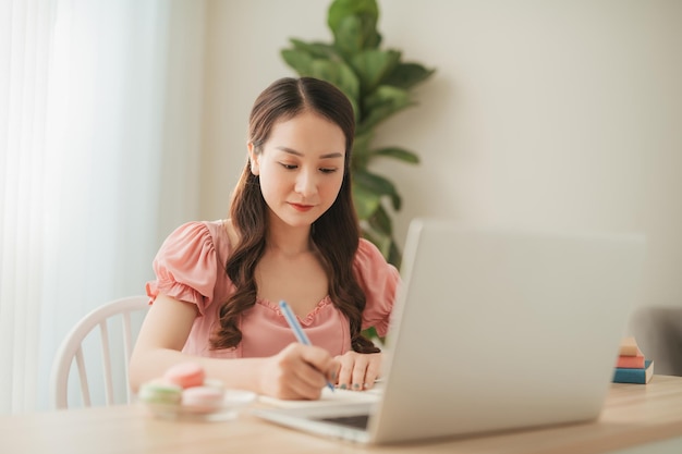 Woman use phone and computer work at home