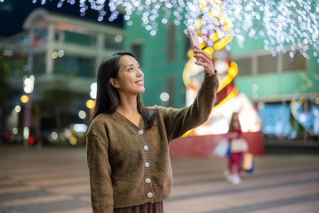 Photo woman use phone to take selfie in city