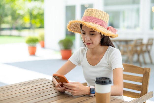 Woman use smart phone and enjoy her coffee at outdoor area coffee shop