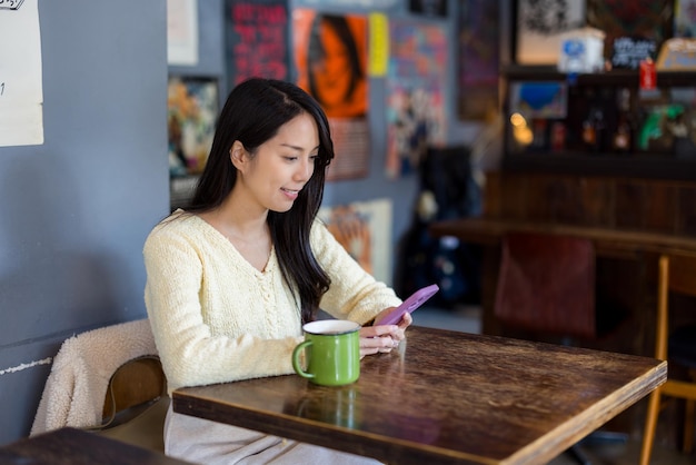 Woman use smart phone inside coffee shop