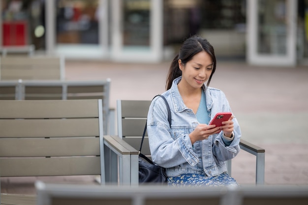 Woman use of smart phone and sit outside