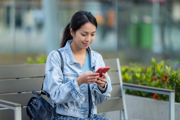 Woman use smart phone and sit outside