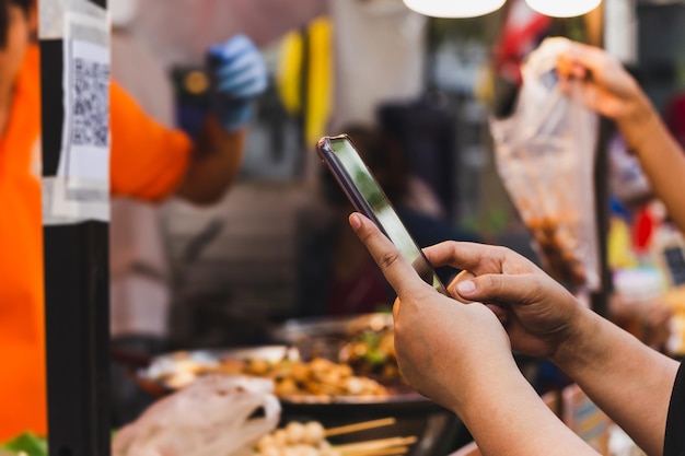 Woman use smartphone scan qr code in food store