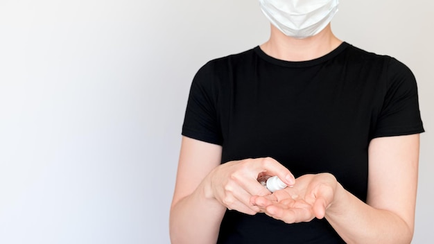 A woman uses antiseptic gel with dispenser on her hands The concept of prevention of infection