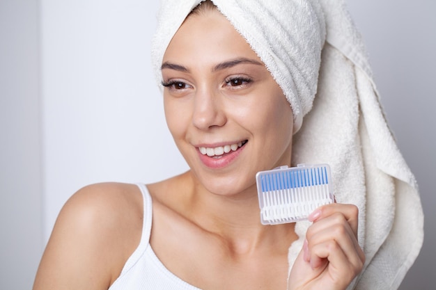 The woman uses brushes to clean the interdental spaces