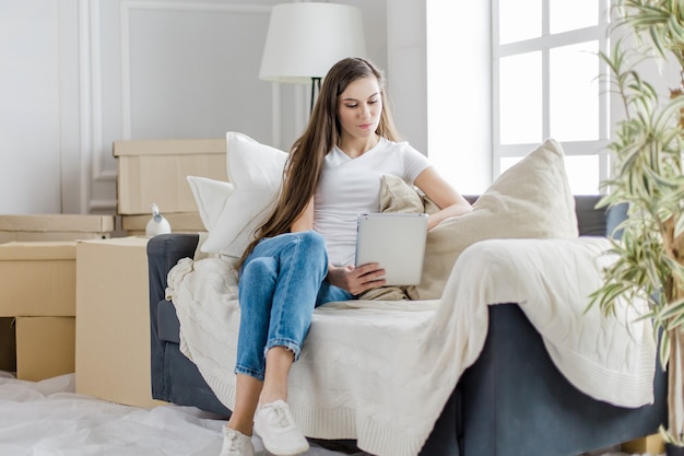 woman uses a digital tablet in her new apartment