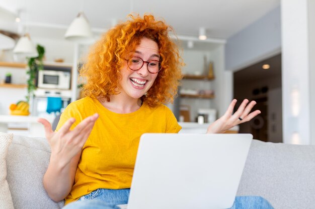 Woman uses a laptop her expression a blend of surprise and excitement With eyes wide and a radiant smile she embodies the joy of discovering something remarkable