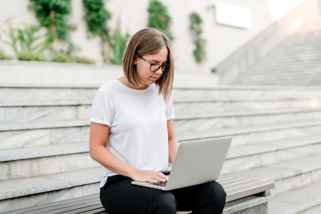 Woman uses laptop in the park