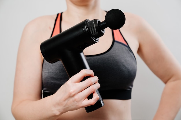 Photo woman uses massage gun