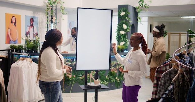 Photo woman uses screen to show client clothes