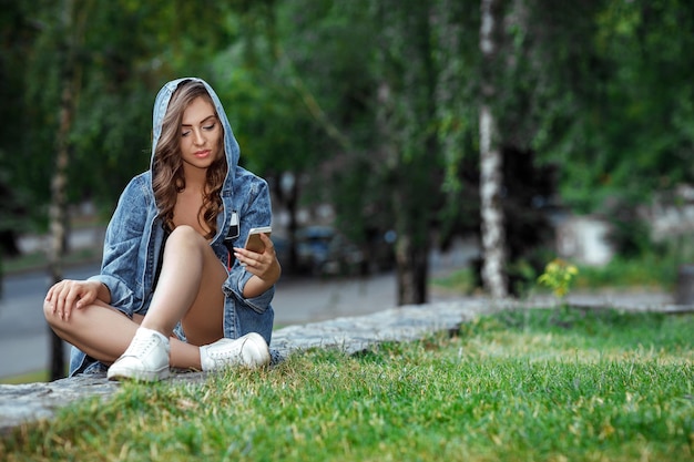 女性は屋外でスマートフォンを使用しています