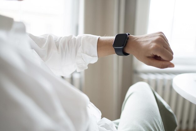 A woman uses a smartwatch on her hand