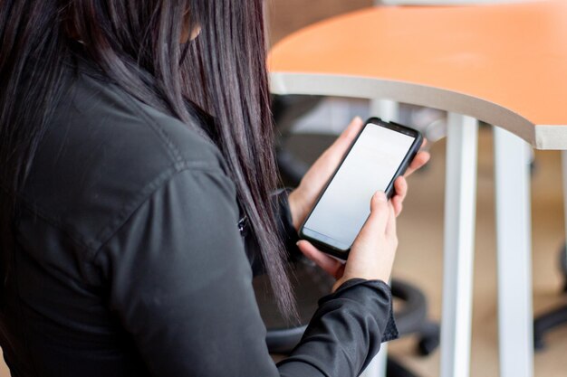 A woman uses a tablet with a blank screen.