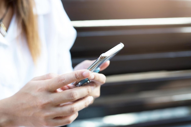 Фото Женщина использует мобильный телефон в поисках телефонного сигнала на фоне горного пейзажа цифровая связь отправка текстовых сообщений друзьям в социальной сети
