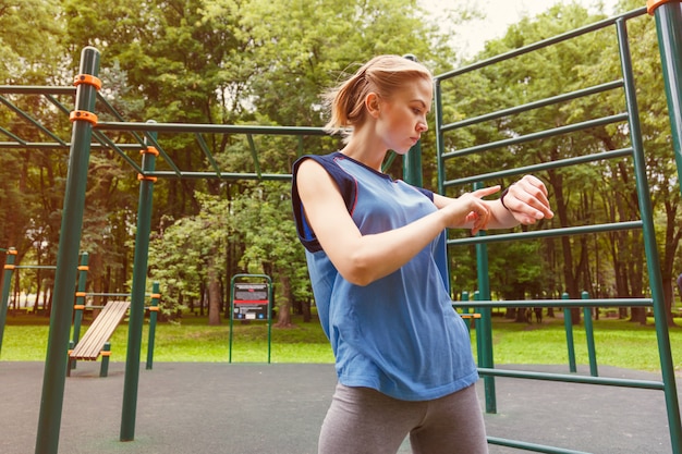 Donna che utilizza l'inseguitore di attività in palestra