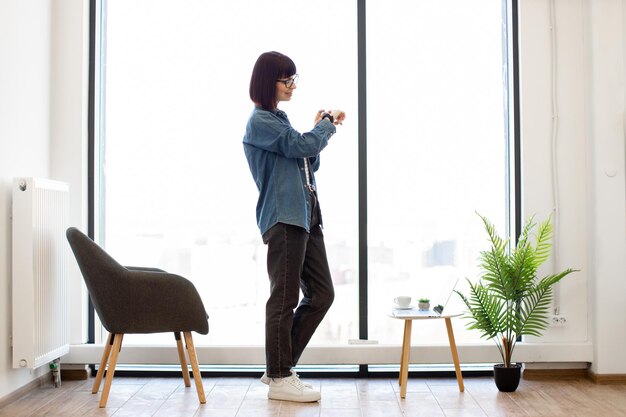 Woman using app on smartwatch during work at office