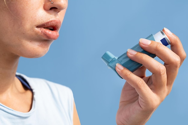 Woman using asthma inhaler during asthma attack