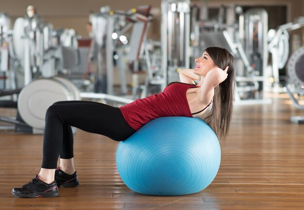 Woman using a ball to work out in a gym