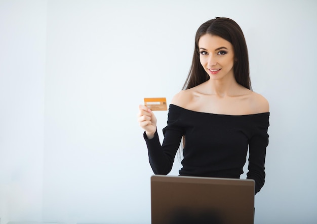 Woman using bank card and laptop in home