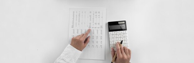 Woman using a calculator and points her finger at the numbers in the financial documents Financialbusiness and money concept Top view