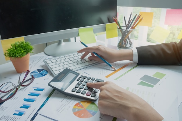 Woman using calculator while working for financial documents 