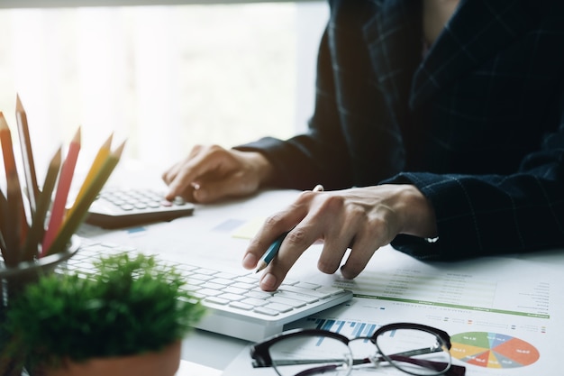 Woman using calculator while working for financial documents 