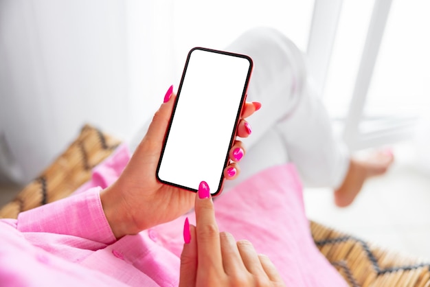 Woman using cell phone at home blank white screen mockup