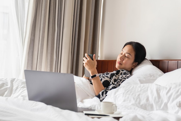 Woman using cell phone and laptop in