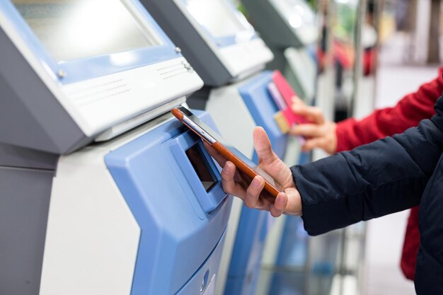 Woman using cellphone for paying her ticket