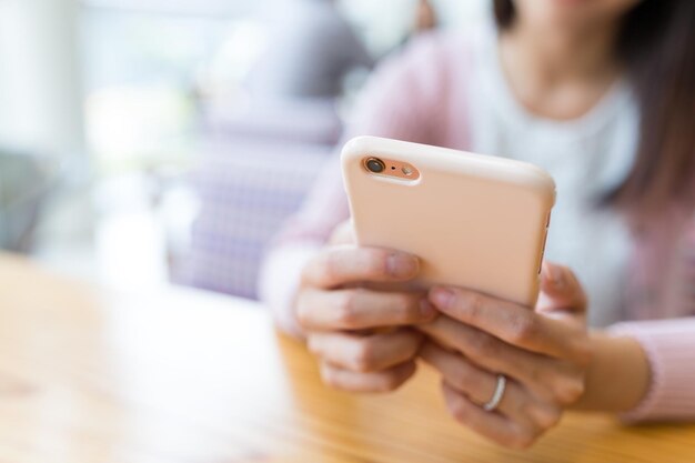 Woman using cellphone in restaurant