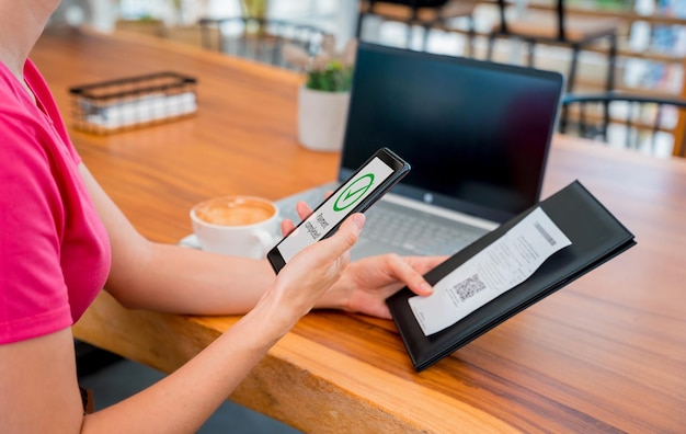 Фото Женщина использует бесконтактную оплату мобильным телефоном с qr-кодом в кафе