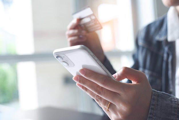 Foto donna che utilizza carta di credito e telefono cellulare per pagamenti digitali e acquisti online