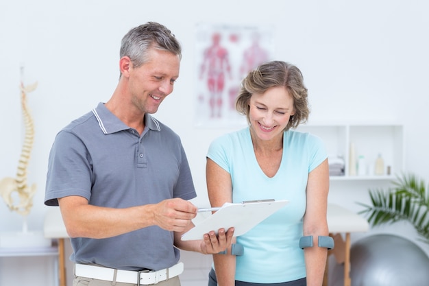 Woman using crutch and talking with her doctor