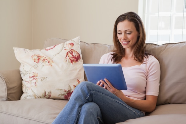 Woman using digital tablet in living room