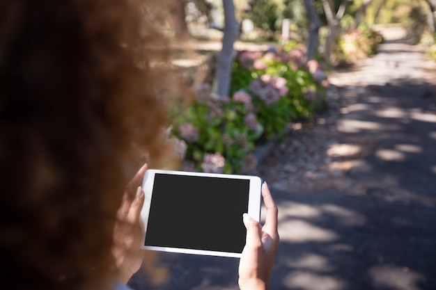 Foto donna che utilizza compressa digitale nel parco