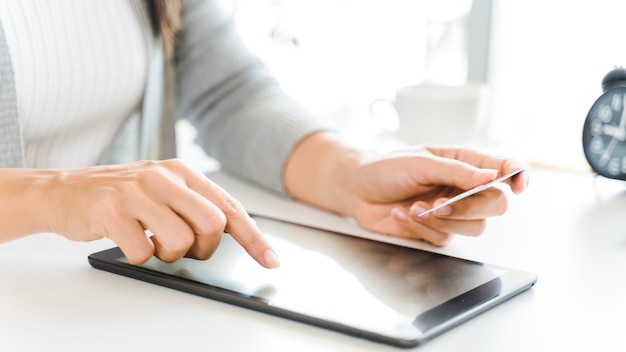 Donna che utilizza un tablet pc digitale con una carta di credito. shopping online, finanza, pubblicità online.