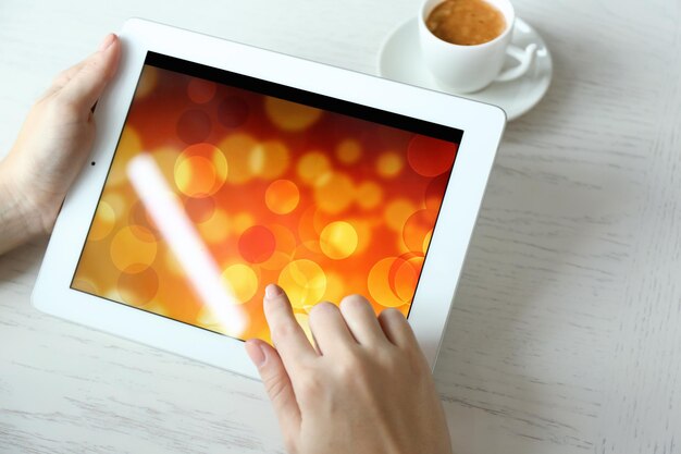 Woman using digital tablet on table close up