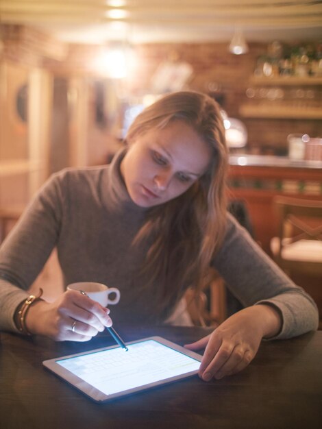 Woman using digital tablet at table