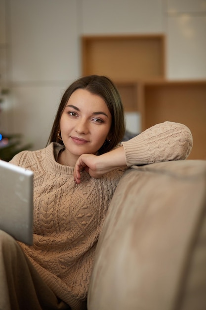 Woman using electronic tab sitting in couch