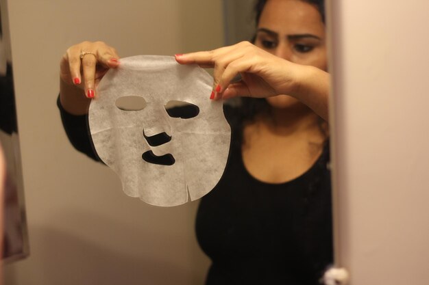 Photo woman using facial mask at home